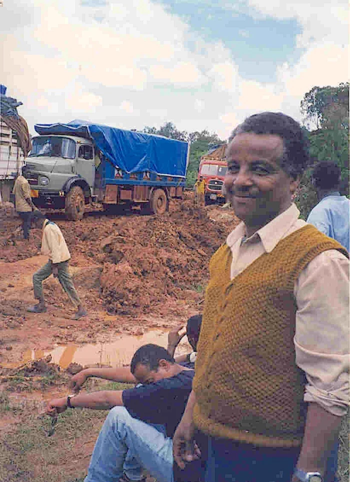 Mikhail Negussie and Teklehaimanot Yigletu beside lorries stranded in deep mud on the road to Assosa